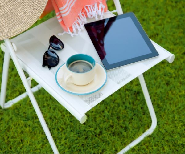chair with ipad, coffee, sunglasses and hat