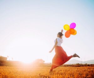 woman running with balloons