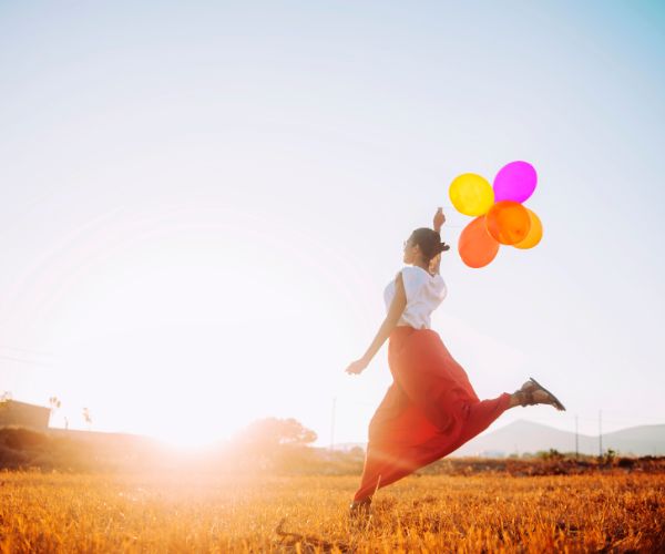 woman running with balloons
